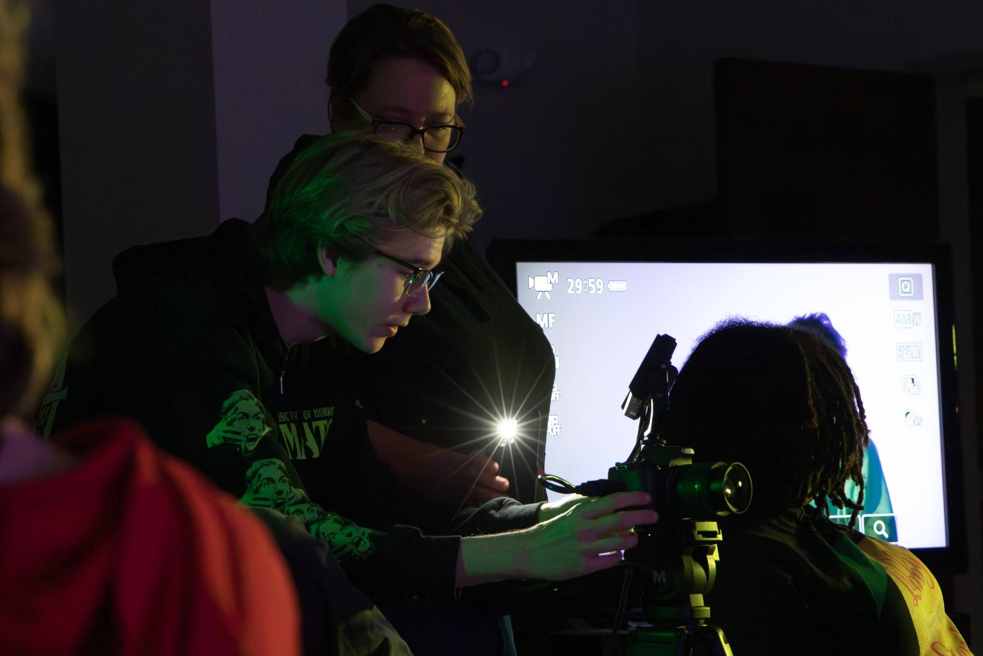 A student and professor looking at a camera