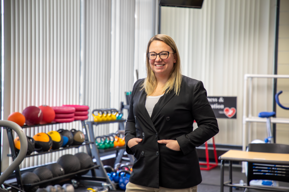 Professor Jackie Rocco standing infront of a weight room
