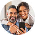 Man and woman smiling while looking at a phone
